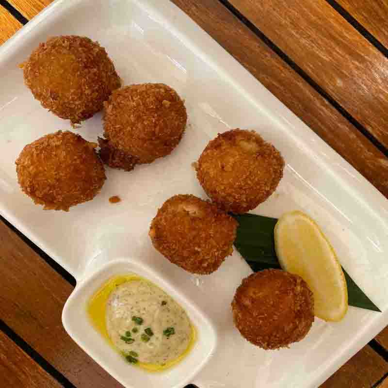 Plate of Dutch bitterballen with mustard dipping sauce and lemon slice — traditional Dutch bar snack served in cafés and restaurants.