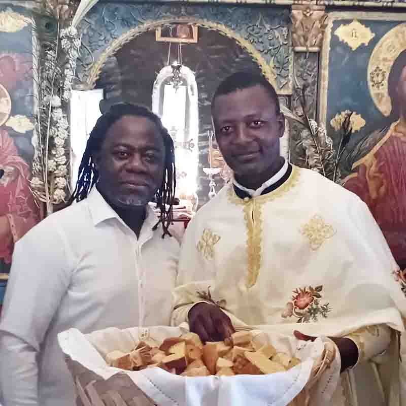 Chrys Mbenga with an Orthodox priest